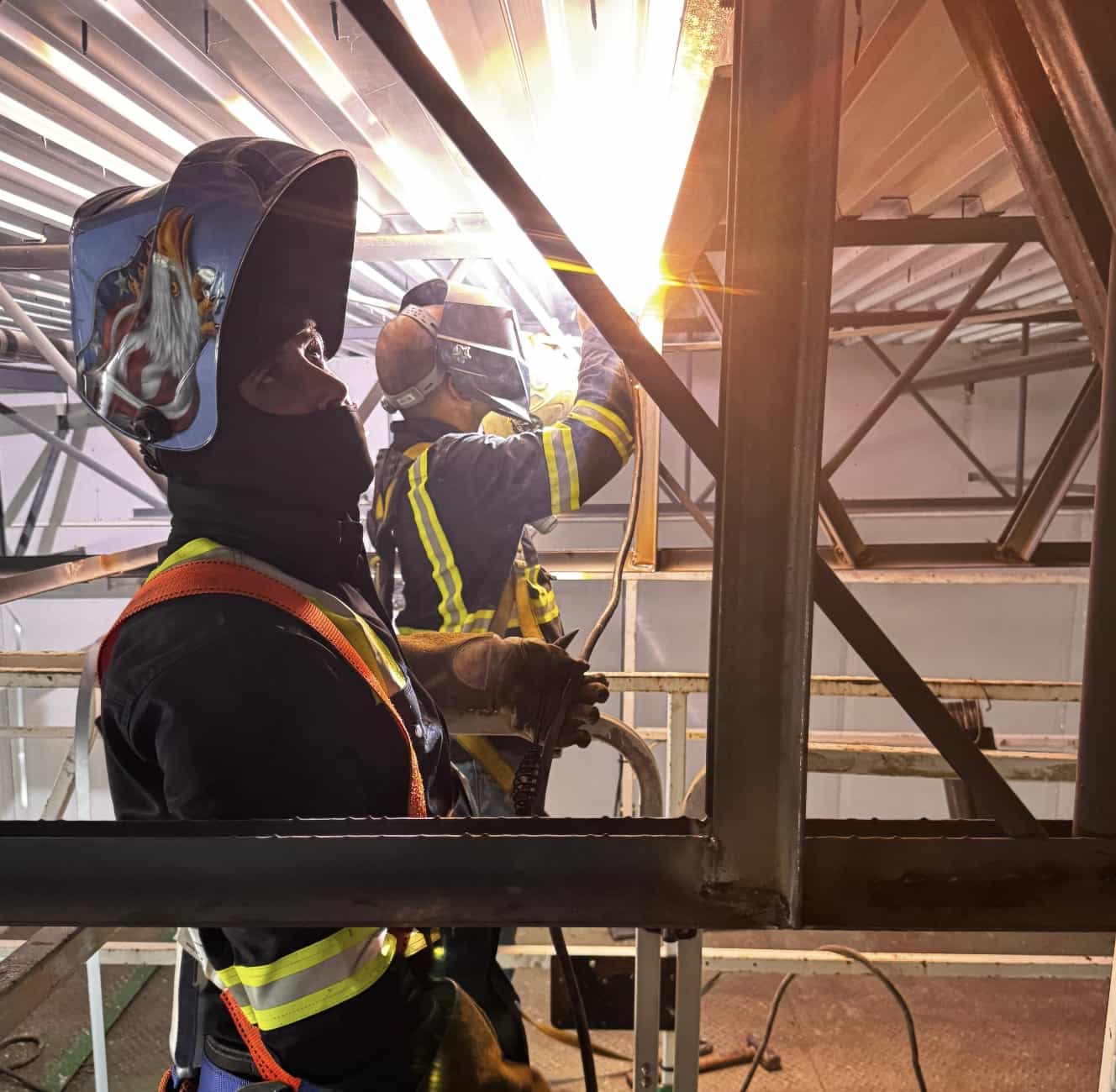 Two welders working a structural steel connection overhead. — Tampa Bay, FL