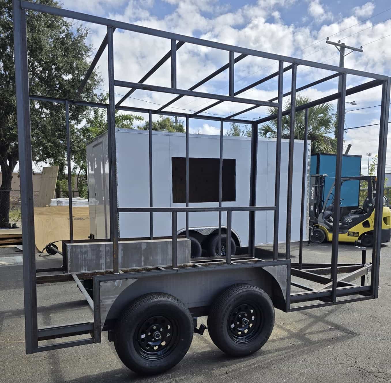 Tandem-axle utility trailer frame with a custom steel cage structure